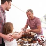 Family Buying Nuts From Stall At Farmers Market
